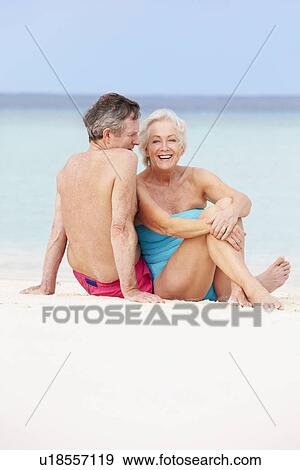 Stock Photo - Senior Couple Relaxing On Beautiful Beach Together. Fotosearch