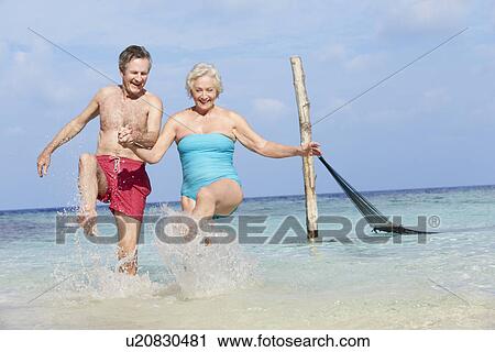 Senior Couple Splashing In Beautiful Tropical Sea View Large Photo Image Stock Image - Senior Couple Splashing In Beautiful Tropical Sea. Fotosearch