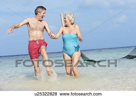Senior Couple Splashing In Beautiful Tropical Sea View Large Photo Image Stock Photo - Senior Couple Splashing In Beautiful Tropical Sea. Fotosearch