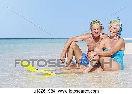 Picture - Senior Couple With Snorkels Enjoying Beach Holiday. Fotosearch