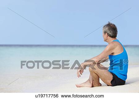 Senior Man In Sports Clothing Relaxing On Beautiful Beach View Large Photo Image Stock Photograph - Senior Man In Sports Clothing Relaxing On Beautiful Beach. Fotosearch