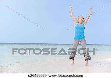 Senior Woman Jumping On Beautiful Beach View Large Photo Image Stock Photo - Senior Woman Jumping On Beautiful Beach. Fotosearch