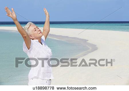 Senior Woman With Arms Outstretched On Beautiful Beach View Large Photo Image Stock Photo - Senior Woman With Arms Outstretched On Beautiful Beach. Fotosearch
