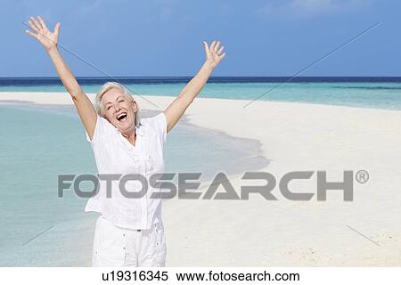 Senior Woman With Arms Outstretched On Beautiful Beach View Large Photo Image Stock Photography - Senior Woman With Arms Outstretched On Beautiful Beach. Fotosearch