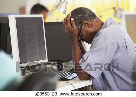 Stressed Man Working At Desk In Busy Creative Office View Large Photo Image Stock Image - Stressed Man Working At Desk In Busy Creative Office. Fotosearch
