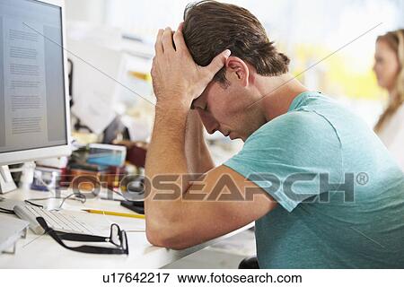 Stressed Man Working At Desk In Busy Creative Office View Large Photo Image Stock Photo - Stressed Man Working At Desk In Busy Creative Office. Fotosearch