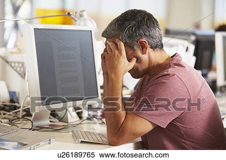 Stressed Man Working At Desk In Busy Creative Office View Large Photo Image Stock Photography - Stressed Man Working At Desk In Busy Creative Office. Fotosearch