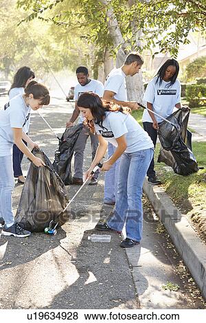 Stock Photo - Team Of Volunteers Picking Up Litter In Suburban Street. Fotosearch