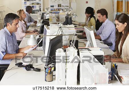 Stock Photo - Team Working At Desks In Busy Office. Fotosearch