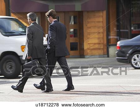 Two Businessman Chatting Whilst Crossing Street View Large Photo Image Stock Photo - Two Businessman Chatting Whilst Crossing Street. Fotosearch