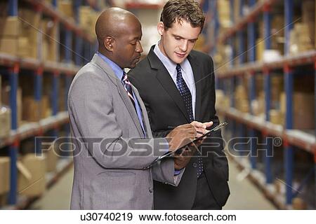 Two Businessmen Having Discussion In Warehouse View Large Photo Image Stock Photo - Two Businessmen Having Discussion In Warehouse. Fotosearch