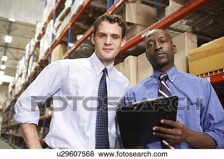Two Businessmen With Clipboard In Warehouse View Large Photo Image Stock Photo - Two Businessmen With Clipboard In Warehouse. Fotosearch