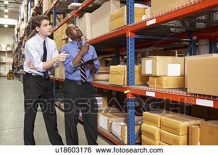 Stock Photograph - Two Businessmen With Clipboard In Warehouse. Fotosearch