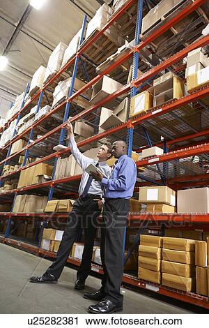 Stock Image - Two Businessmen With Digital Tablet In Warehouse. Fotosearch