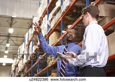 Stock Photograph - Two Businessmen With Digital Tablet In Warehouse. Fotosearch