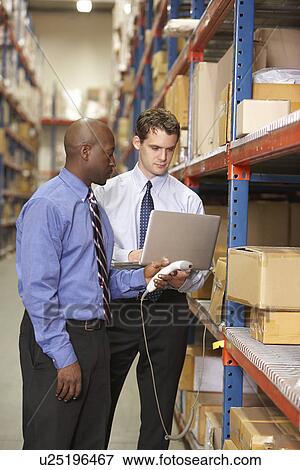 Stock Photo - Two Businessmen With Laptop In Warehouse. Fotosearch