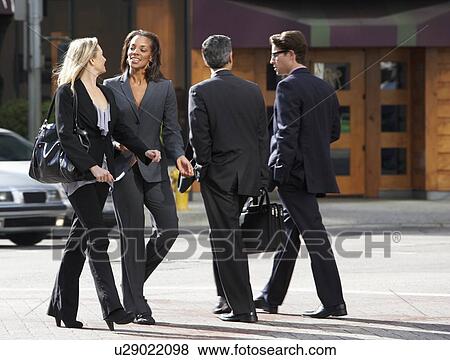 Two Businesswomen Chatting Whilst Crossing Street View Large Photo Image Stock Photo - Two Businesswomen Chatting Whilst Crossing Street. Fotosearch