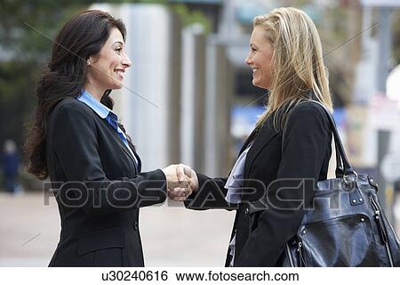 Stock Photograph - Two Businesswomen Shaking Hands Outside Office. Fotosearch