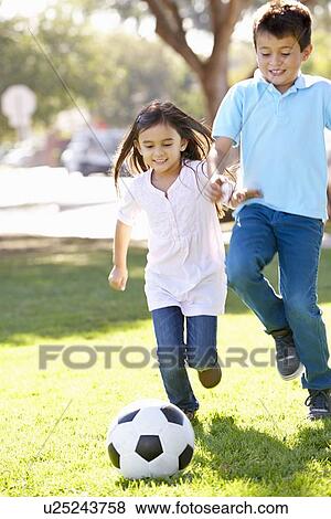 Stock Photo - Two Children Playing Soccer Together. Fotosearch