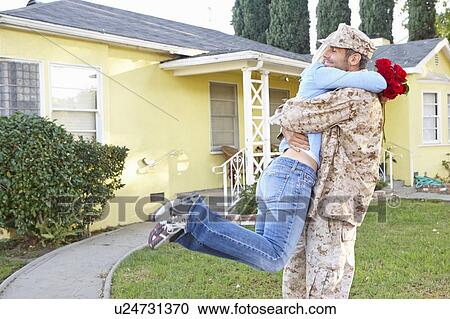 Stock Image - Wife Welcoming Husband Home On Army Leave. Fotosearch