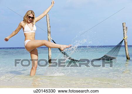 Stock Image - Woman In Bikini Splashing In Beautiful Tropical Sea. Fotosearch