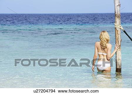 Picture - Woman In Bikini Standing In Beautiful Tropical Sea. Fotosearch
