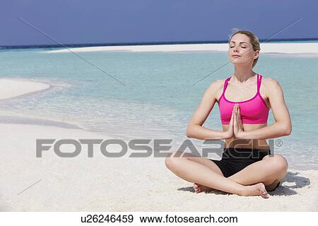 Stock Photo - Woman Meditating On Beautiful Beach. Fotosearch
