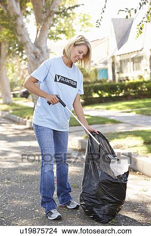 Picture - Woman Picking Up Litter In Suburban Street. Fotosearch