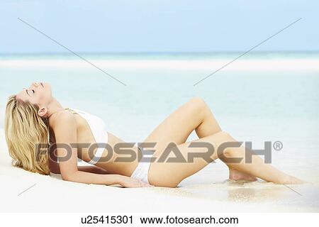 Stock Image - Woman Sunbathing On Beautiful Beach Holiday. Fotosearch