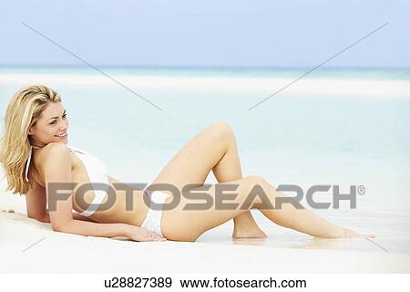 Stock Photo - Woman Sunbathing On Beautiful Beach Holiday. Fotosearch