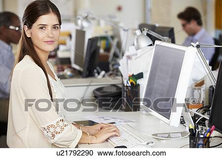 Woman Working At Desk In Busy Creative Office View Large Photo Image Stock Image - Woman Working At Desk In Busy Creative Office. Fotosearch