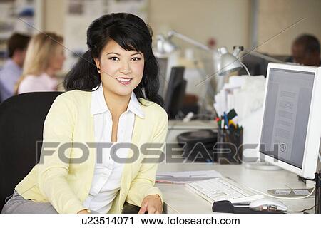 Woman Working At Desk In Busy Creative Office View Large Photo Image Stock Image - Woman Working At Desk In Busy Creative Office. Fotosearch
