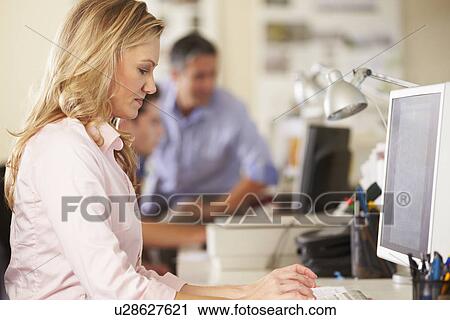 Woman Working At Desk In Busy Creative Office View Large Photo Image Stock Image - Woman Working At Desk In Busy Creative Office. Fotosearch