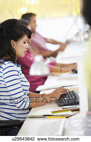 Woman Working At Desk In Busy Creative Office View Large Photo Image Stock Image - Woman Working At Desk In Busy Creative Office. Fotosearch