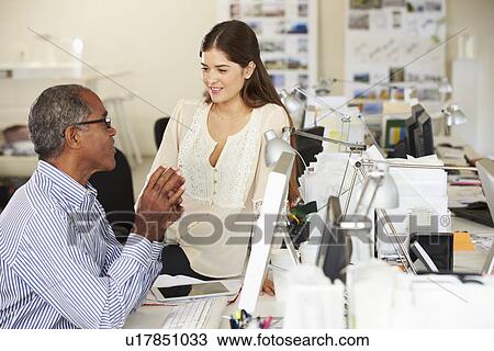 Stock Image - Workers At Desks In Busy Creative Office. Fotosearch