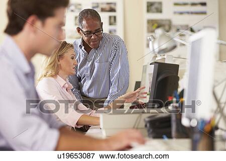 Stock Photo - Workers At Desks In Busy Creative Office. Fotosearch