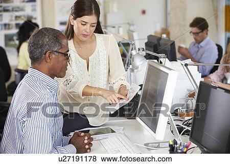 Stock Photo - Workers At Desks In Busy Creative Office. Fotosearch