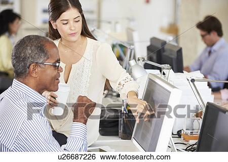 Stock Photograph - Workers At Desks In Busy Creative Office. Fotosearch