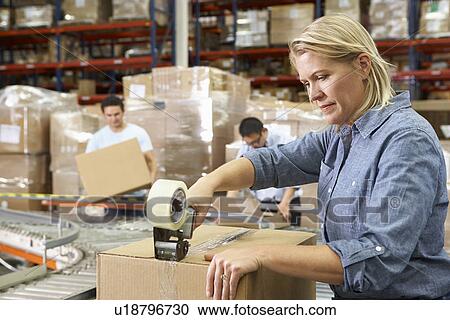 Stock Image - Workers In Distribution Warehouse. Fotosearch