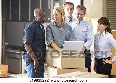 Stock Image - Workers In Distribution Warehouse. Fotosearch