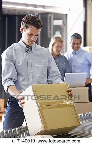 Stock Photo - Workers In Distribution Warehouse. Fotosearch
