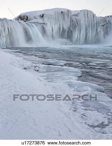 Stock Photograph - Godafoss waterfall frozen in winter, Iceland. Fotosearch