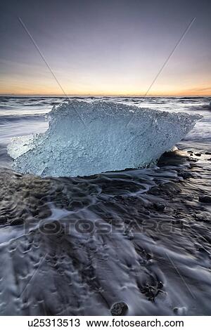 Stock Image - Iceberg on beach at sunrise, Jokulsarlon, Iceland. Fotosearch
