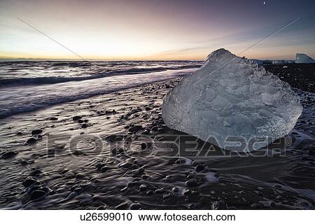 Stock Image - Iceberg on beach at sunrise, Jokulsarlon, Iceland. Fotosearch