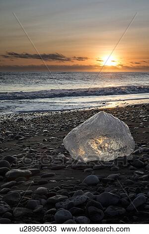 Stock Image - Iceberg on beach at sunset, Jokulsarlon, Iceland. Fotosearch