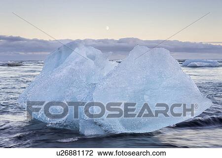 Stock Image - Icebergs at Jokulsarlon beach, sunset with moon rising, Iceland. Fotosearch