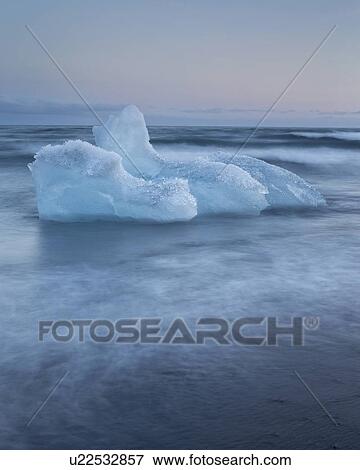 Stock Photo - Icebergs at Jokulsarlon beach, sunset, Iceland. Fotosearch