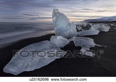 Stock Photo - Icebergs at Jokulsarlon beach, sunset, Iceland. Fotosearch