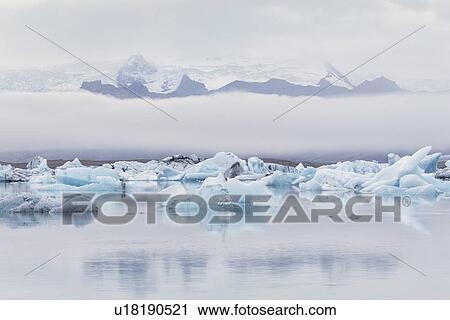 Stock Image - Icebergs at Jokulsarlon lagoon, with glacier, sunrise, Iceland. Fotosearch