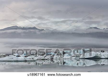Stock Image - Icebergs at Jokulsarlon lagoon, with glacier, sunrise, Iceland. Fotosearch